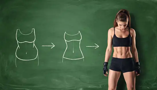 physically fit woman standing infront of a board